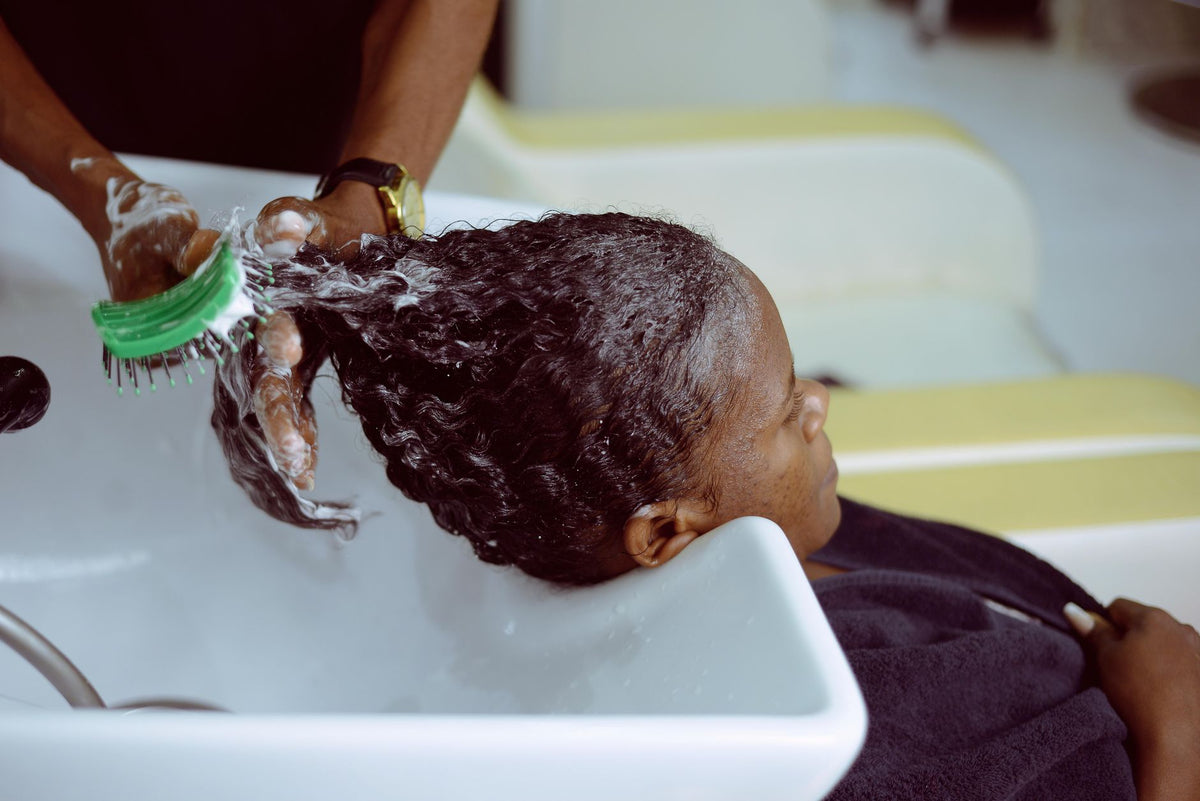 A woman receives a hair wash at a salon with foam and care