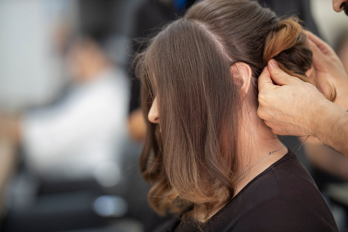 Close-up of a hairstylist creating an elegant hairstyle for a woman in a salon