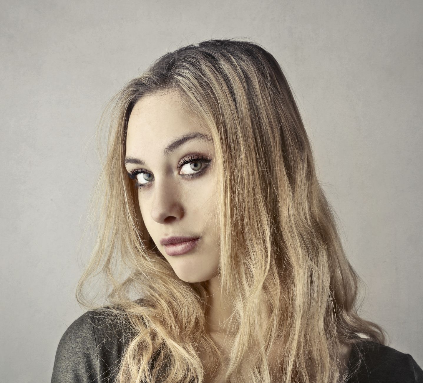 Close-up portrait of a young woman with blonde hair and captivating eyes