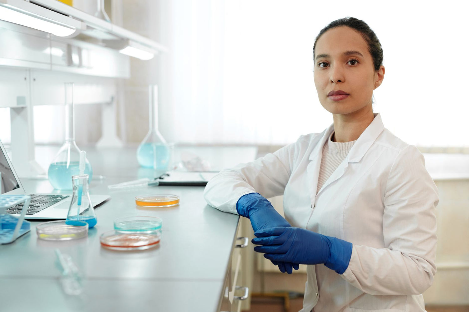 Female scientist in a lab coat conducting research with laboratory glassware