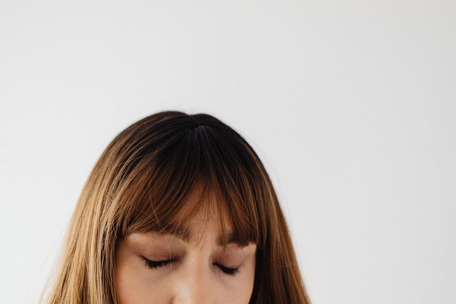 Close-up portrait of a woman with closed eyes and brunette hair, exuding calmness and serenity