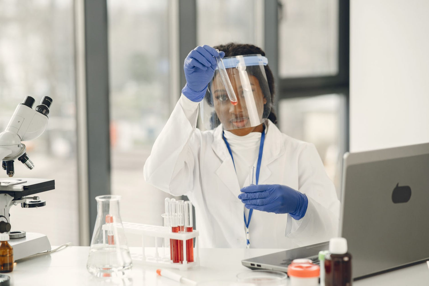 Female scientist working with test tubes and microscope in a laboratory
