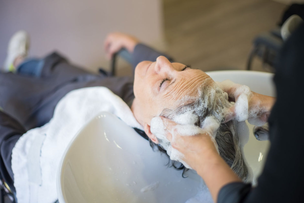 Woman enjoying a relaxing hair wash with shampoo and massage in a modern hair salon