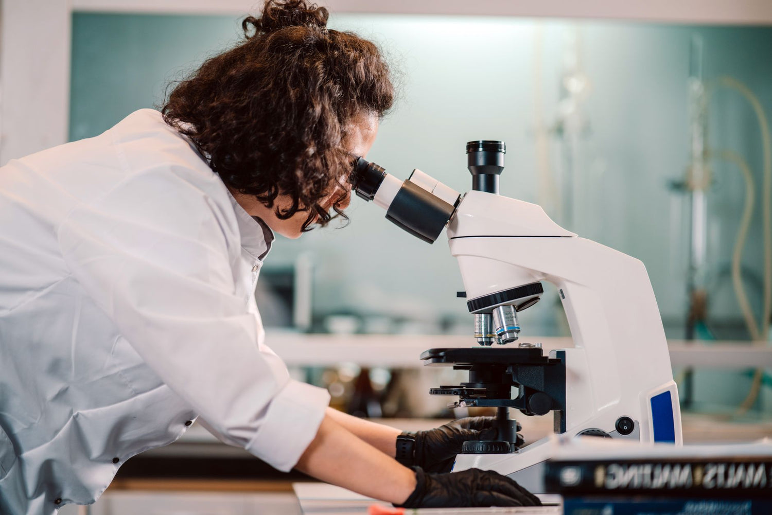 A woman scientist using a microscope in a laboratory setting