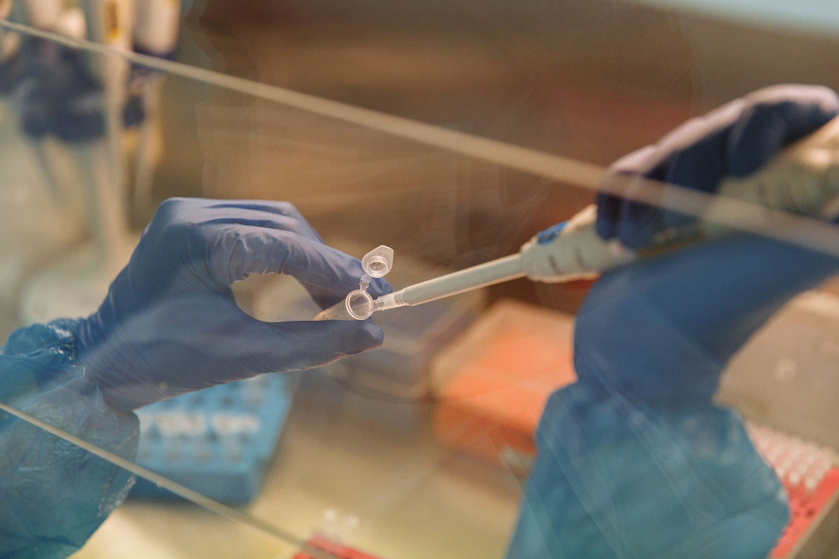 Close-up of scientist using a pipette with test tubes in a laboratory setting